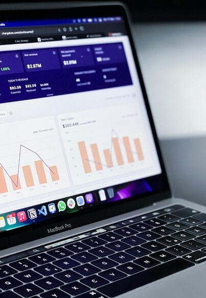 The image displays a business analytics dashboard on a MacBook Pro screen, highlighting key performance indicators.