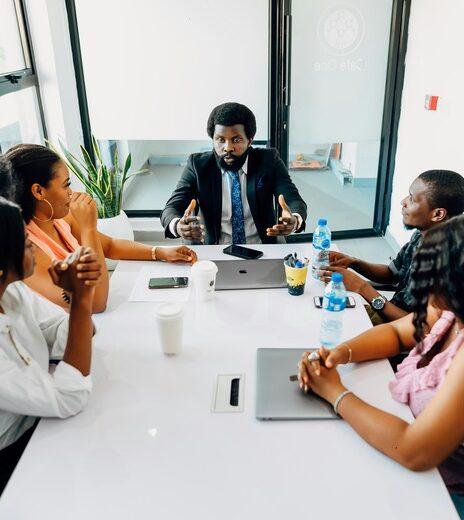 This image depicts a professional group meeting in a bright, modern office setting.