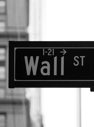 This image features the iconic street sign for Wall Street, located in New York City's Financial District.